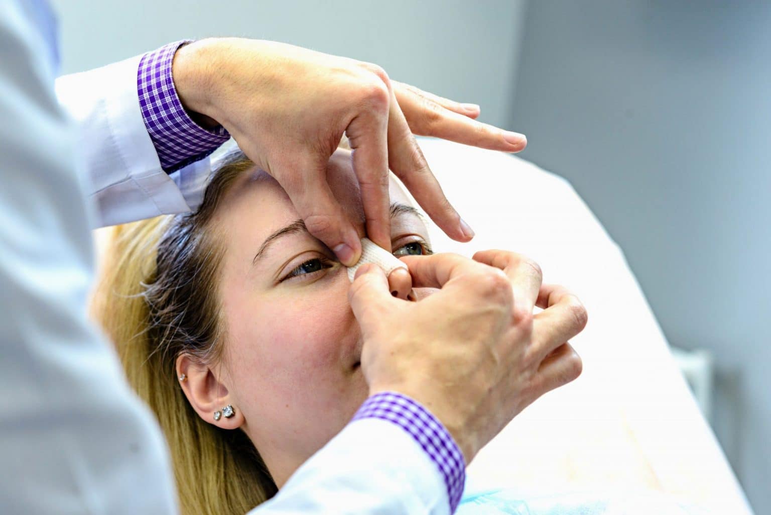 Nasal-Fractures Doctor examining the nose of a female patient for a nasal fracture.